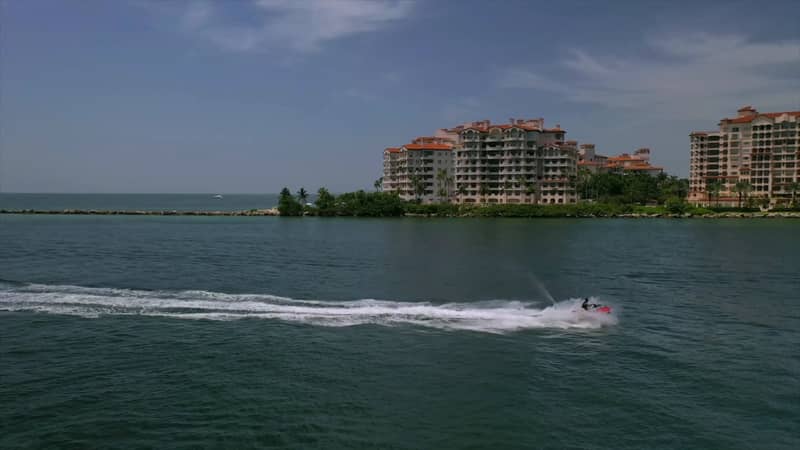 Jet ski crossing the water in front of Miami waterfront buildings